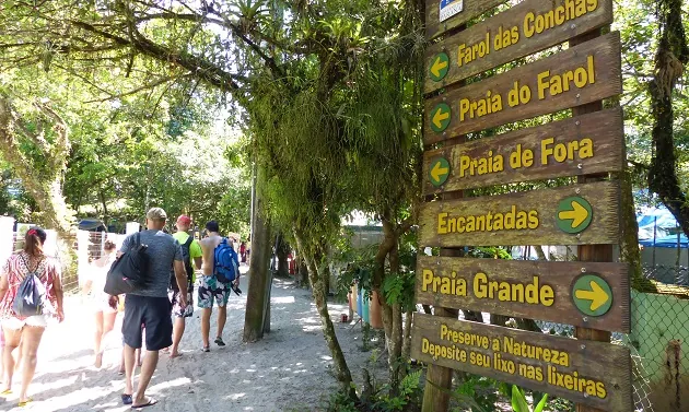 Placas de trilha indicando as praias e o tempo até cada uma