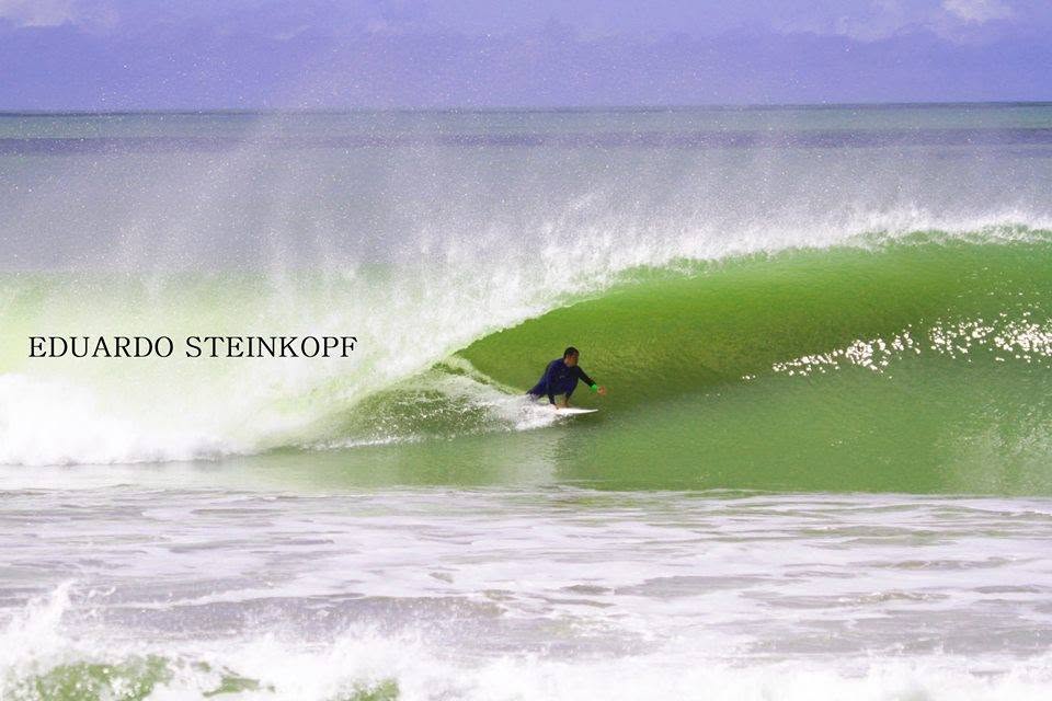 O surfista Duduzinho de mão na parede dentro da esquerda tubular de Regência, no litoral norte do Espírito Santo
