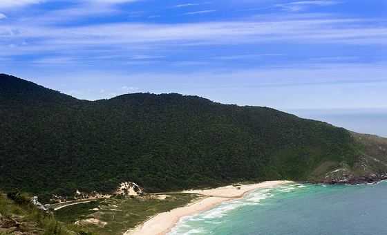 A praia da Lagoinha do Leste vista do alto, cercada de morros cobertos de mata, no sul de Florianópolis